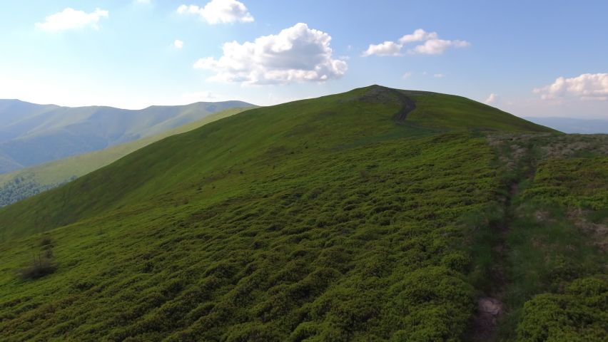 Aerial flight over green hill mountains. FPV Dynamic drone shot.