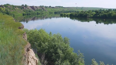 A beautiful cliffy bank of the Siberian river. Martins fly over the cliff