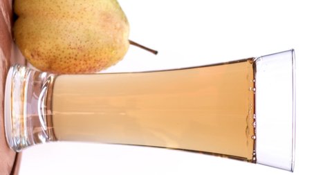 Yellow pear juice in cold ice with fresh and yummy pears, natural and organic fruits in white background. Filmed high speed cinema camera, slow motion footage, 8K downscale, 4K.
