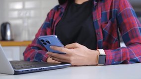 Freelancer woman communicating online. Millenial person using modern gadgets for networking and distant work. Female wearing modern smart watches and browsing blue smartphone for communication