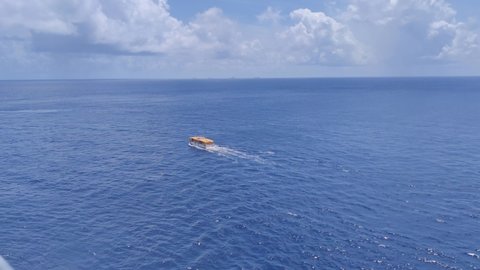 A lifeboat of Cruise ship on a rescue mission in middle of the Caribbean ocean | Lifeboat searching for something in middle of the ocean on rescue mission in Caribbean ocean video background in 4K