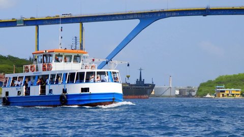 Willemstad , Curaçao - 01 05 2022: Ferry in the Sint Annabaai canal docking below the Queen Juliana Bridge in Willemstad, Curacao. 