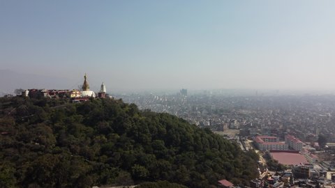 A view of the Swayambhunath Stupa on the top of a hill with the city of Kathmandu, Nepal and the Himalayan Mountains in the background.