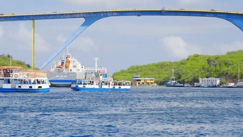 Willemstad , Curaçao - 01 05 2022: Ferries cruising along Sint Annabaai near the Queen Juliana Bridge in Willemstad, Curacao