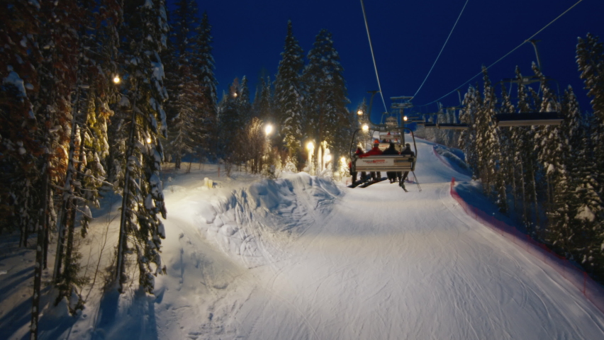Skilift at night with riders moving down the slope Royalty-Free Stock Footage #1087307831