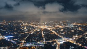 Amazing motion timelapse of Moscow center at night, view from above. Picturesque aerial panorama of Moscow with evening lights from buildings, streets and traffic, and clouds moving above the city.