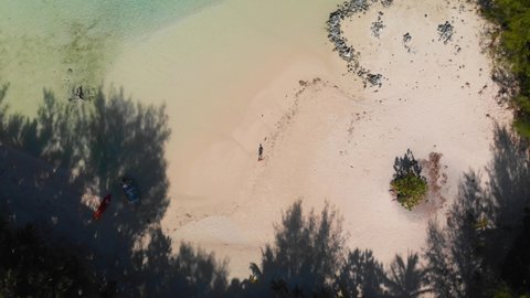 Flying above male tourist strolling around the paradise island with gorgeous white sand beaches and lush palm trees. Rarotonga, Cook islands 