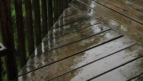 Summer rain falling on wooden deck. Half-speed 4K Clip. Ontario, Canada.