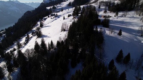 Drone flight over remote houses on a snowy mountain resort in Switzerland