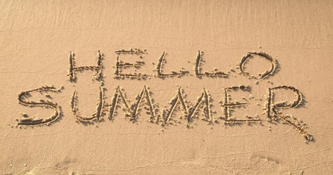 Greeting summer on the beach. The beach say hello to summer. A view of written words on the sea sand in the day light. Hello summer.