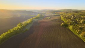 Aerial view of plowed agricultural fields with cultivated fertile soil prepared for planting crops between green woods in spring at sunset - Powered by Shutterstock - Get 15% off with code: PIKWIZARD15