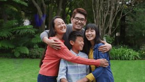 Animation of good vibes text over smiling asian family embracing. social media and communication interface concept digitally generated video.