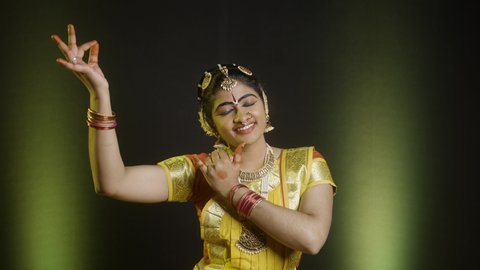 Indian bharathanatyam dancer in krishna pose or gesture with eye closed performing on stage - concept of indian culture, traditional dress and classic dancer