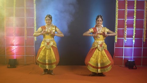 Traditional young bharathnatyam dancers performing on stage - concept of indian culture and professional classical dancers.