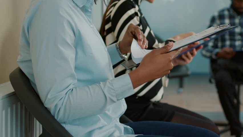 Female applicant looking at cv files and waiting to attend hiring meeting, preparing for job interview and career opportunity. Woman in queue feeling nervous about candidate selection.