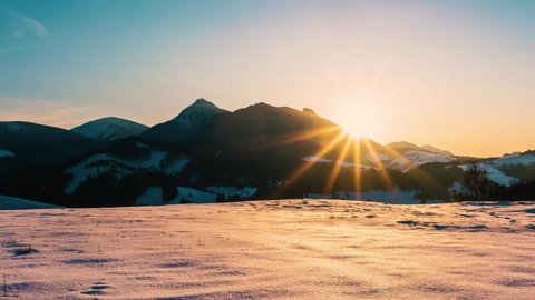 Sun is going down in beautiful winter nature scenery at sunset in cold snowy mountains landscape Time lapse