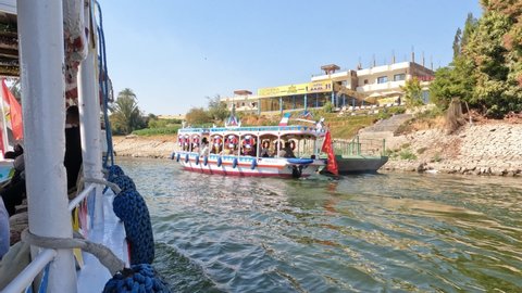 Group of tourists crossing the Nile river in bright, traditional Egyptian motorboats. FEB 07 2022, LUXOR EGYPT