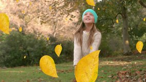 Animation of autumn leaves falling over happy caucasian woman in park. autumn, fall and seasons concept digitally generated video.