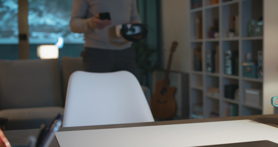 Man sitting at desk and wearing a VR headset, virtual reality experience concept