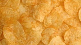 Background of Potato chips rotating close up. Nutrition, relaxation concept. Top view, copy space. High quality 4k footage