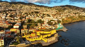 Top view of Funchal town on Madeira. Day drone flight around the white town with red roofs. Aerial view of Madeira, Portugal.