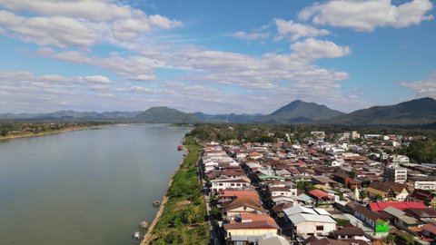 Aerial reverse footage of the Walking Street and the Mekong River then Laos across the river, Chiang Khan, Loei in Thailand.