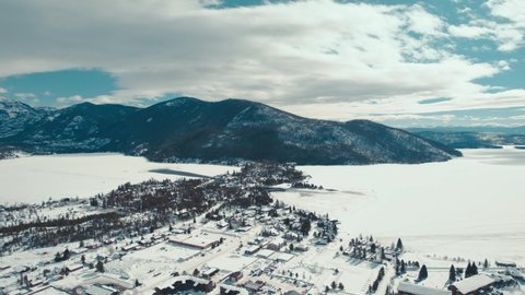 Grand Lake, Colorado. Drone Aerial View Of Frozen Lakes Next To Snowcapped Winter Town With Alpine Mountain In The Background.
