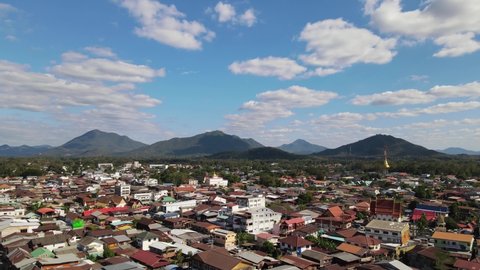 An aerial footage reversing from the horizon revealing mountains and rooftops in Chiang Khan, Loei in Thailand.