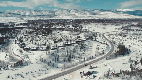 Grand Lake Colorado. Drone Aerial View Flying Over Snow Covered Rocky Mountain Town Near Alpine Forest After Wild Forest Fire With Beautiful Mountain Range In Background.