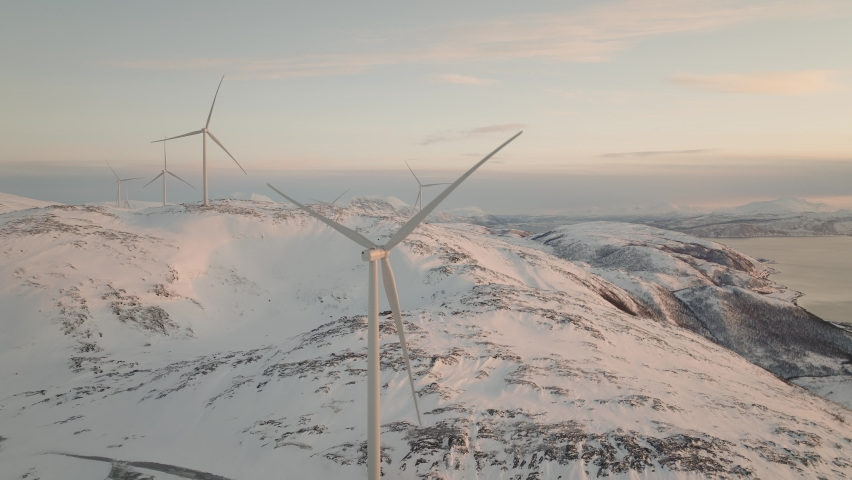 Wind turbine spins and other wind turbines stay still. Renewable clean energy.