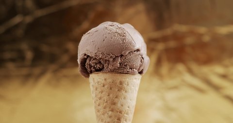 Time lapse Melting of chocolate ice cream on cone. Liquid after melting flows from the cones slowly. Food concept.