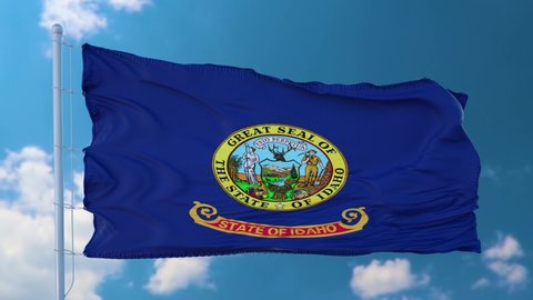 Idaho flag on a flagpole waving in the wind in the sky. State of Idaho in The United States of America