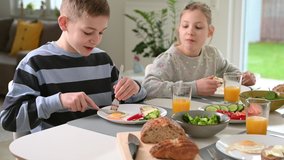 4K video of teen children having healthy breakfast at home in the morning 