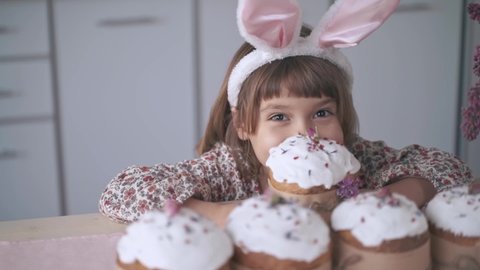 Funny bunny child girl holds an Easter cake in his hands. Happy Easter. Homemade cakes for holidays, healthy food, healthy sweets for children