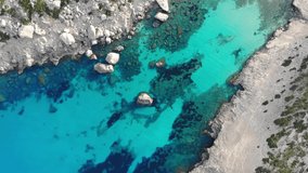 Drone aerial video of picturesque bay with blue turquoise water, corals and rocks on Spanish island of Palma de Mallorca. Green bushes and stones at hidden isolates island beach. Spain, Europe nature.