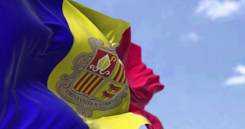 Detail of the national flag of Andorra waving in the wind on a clear day. Andorra is a sovereign landlocked microstate in Europe. Selective focus. Seamless looping in slow motion