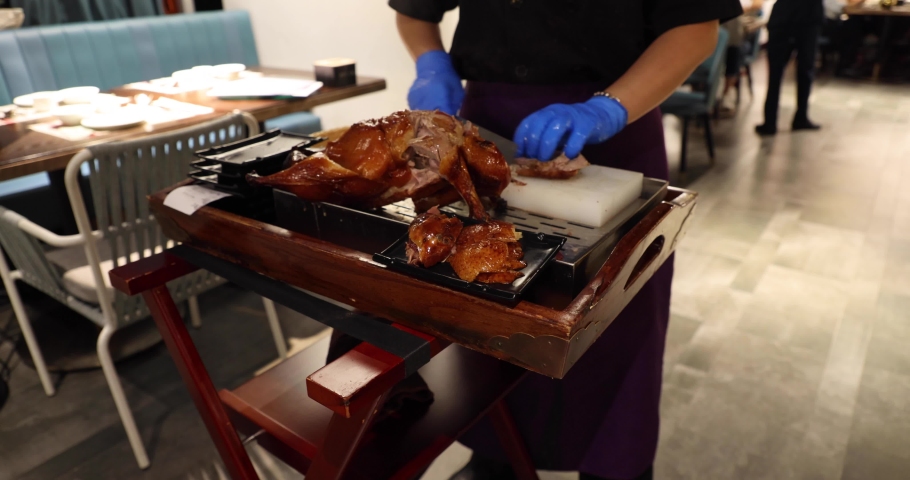Cutting and Dressing of Peking Roast Duck in restaurant, a famous dish that has been prepared since the imperial era, and is now considered one of China's national foods. | Shutterstock HD Video #1087394516