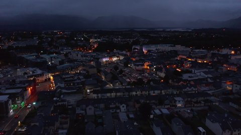 Aerial panoramic shot of town after sunset. Evening footage of colour illuminated facades in city centre. Killarney, Ireland
