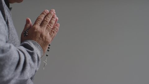 Senior Mans Hands Holding Some Rosary Beads with Copy Space. 
close-up shot.
