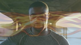 Animation of yellow trails over african american sportsman. global sports, healthy lifestyle and digital interface concept digitally generated video.