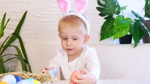Funny happy child boy with easter eggs and bunny ears dancing and singing. Easter concept, happy childhood. Easter Egg Hunt. Slow motion.
