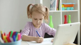 little girl learns to draw online using internet and tablet computer
