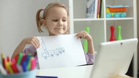 little girl learns to draw online using internet and tablet.