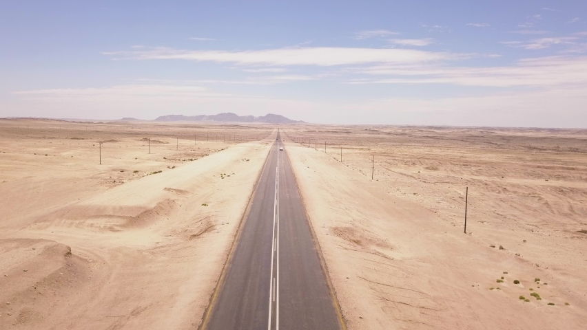 Car driving down a long straight road in the desert | Shutterstock HD Video #1087414778