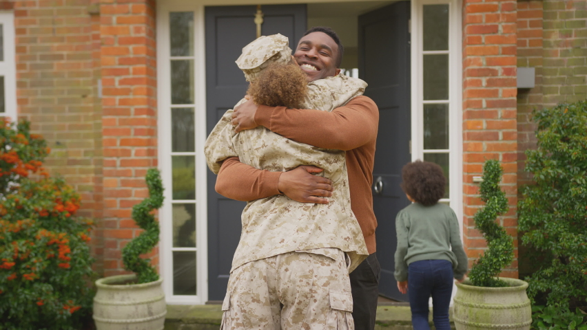 Military family open front door and run to greet mother returning home on leave - shot in slow motion