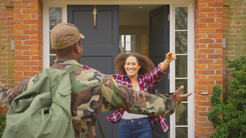 Military family open front door and run to greet father returning home on leave - shot in slow motion