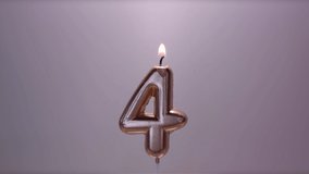 Congratulatory video with a burning wax candle in the form of a number. Paraffin candle in the shape of the number 4 melts. Drops of wax drip from the heat. - Powered by Shutterstock - Get 15% off with code: PIKWIZARD15