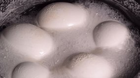 Full HD food video for Easter. White large chicken eggs are boiled in a saucepan before painting.
