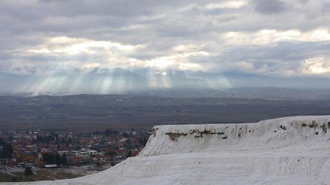 Footage of the travertine terraces in Pamukkale, Turkey, with a dramatic sky in background.