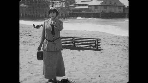 CIRCA 1915 - In this silent comedy, a man (Charlie Chaplin) flirts with a woman on a beach.